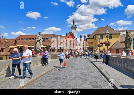 Würzburg, Allemagne - juin 2022: Touristes à l'ancien pont principal appelé 'Alte Mainbrücke', un symbole de la ville et célèbre attraction touristique Banque D'Images