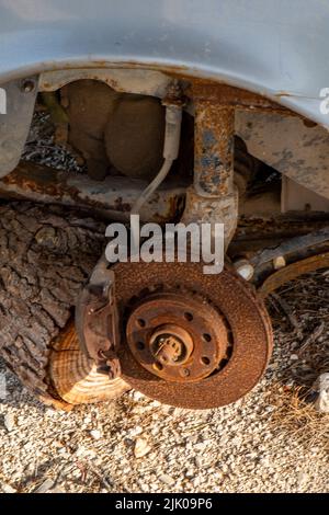 disque de frein de voiture ancienne rouillé exposé aux éléments d'une voiture à la ferraille, corrosion des pièces de voiture ancienne, amortisseur de voiture et tambour de frein recouvert de rouille et corrodé. Banque D'Images