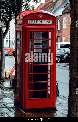 Un cliché vertical d'une cabine téléphonique rouge après la pluie dans une rue de Londres Banque D'Images