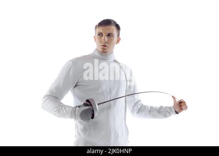 Portrait d'un tireur professionnel en costume d'escrime et masque tenant une petite épée isolée sur fond blanc. Sport, émotions, énergie, compétences Banque D'Images