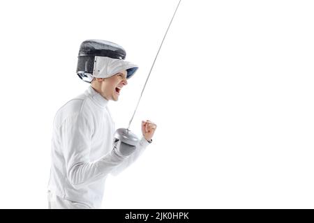 Portrait d'un tireur professionnel en costume d'escrime et masque tenant une petite épée isolée sur fond blanc. Sport, émotions, énergie, compétences Banque D'Images