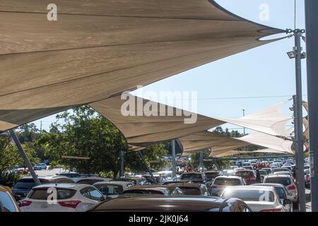 Ombre navigue au-dessus des véhicules dans le parking du centre commercial sur la Gold Coast, Queensland, Australie. Voitures protégées contre la forte lumière du soleil et la chaleur. Banque D'Images