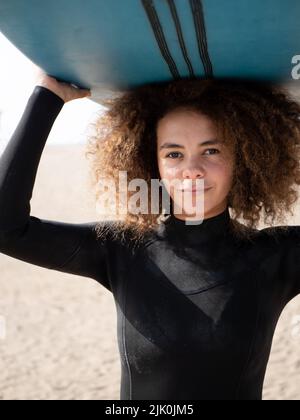 Surfeuse multiraciale jeune femme avec un portrait de cheveux afro Banque D'Images