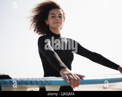 Jeune surfeuse multiraciale avec un portrait de cheveux afro Banque D'Images