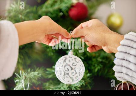 Noël est une douche de bébé qui est allée totalement à la mer. Une femme méconnaissable décorant un arbre de Noël à la maison. Banque D'Images