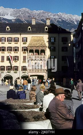 Dans la vieille ville d'Innsbruck. Vue de Herzog-Friedrich-Straße à Goldenes Dachl. Les piétons sont assis devant.Tyrol, Autriche,1970s. Banque D'Images