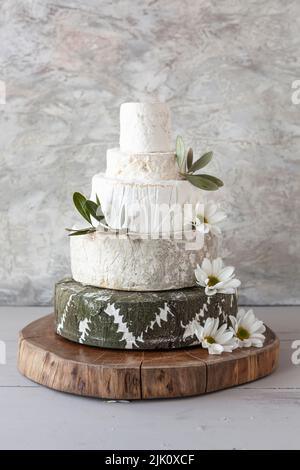 Cheese Wedding Cake - des roues de fromage disposées comme un gâteau de mariage à plusieurs niveaux, avec des fleurs Banque D'Images