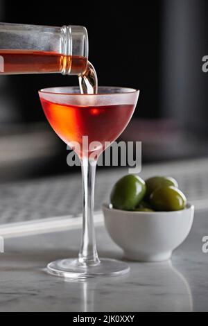 Le Negroni froid est servi dans un élégant verre servi avec des olives sur un bar Banque D'Images