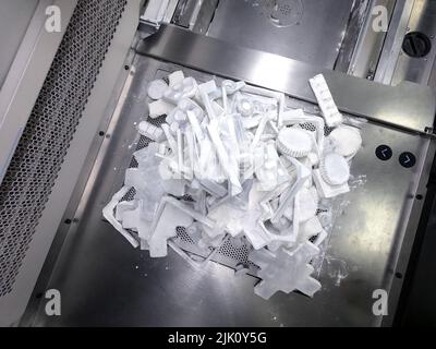 Objets et modèles imprimés sur une imprimante industrielle 3D en poudre de plastique blanc en laboratoire. Relevage de la surface de travail. Impression Multi Jet Fusion MJF 3D. Nouvelles technologies imprimante 3D Banque D'Images