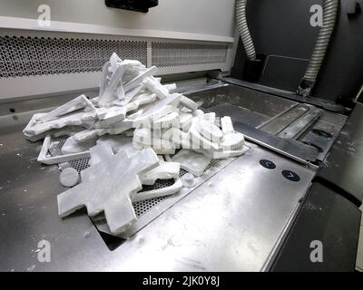 Objets et modèles imprimés sur une imprimante industrielle 3D en poudre de plastique blanc en laboratoire. Impression Multi Jet Fusion MJF 3D. Technologie d'additif automatisée. Nouvelles technologies imprimante 3D Banque D'Images