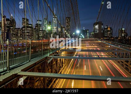 Trafic traversant le pont de Brooklyn avec les gratte-ciel de Manhattan au-delà de la nuit, Manhattan, New York, États-Unis d'Amérique, Amérique du Nord Banque D'Images