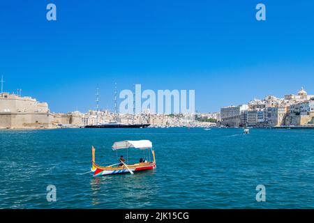 Ferry traditionnel traversant le Grand Harbour, avec le superyacht maltais Falcon en arrière-plan, la Valette, Malte, Méditerranée, Europe Banque D'Images