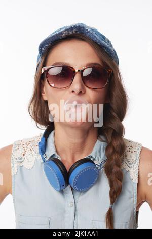 Cool jeune femme dans des lunettes de soleil mâchant bubblegum Banque D'Images