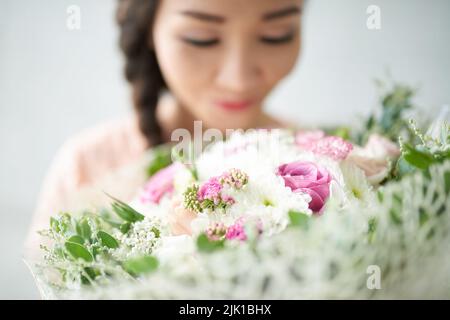 Femme appréciant l'odeur de beau bouquet, foyer sélectif Banque D'Images