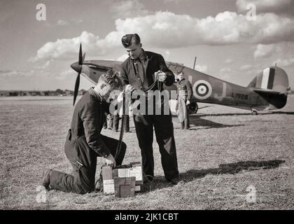 Les armuriers préparant des ceintures de munitions pour un Hawker Hurricane Mk I de l'escadron n° 312 (tchèque) RAF.l'ouragan, un chasseur britannique à siège unique des 1930s–40s, a été éclipsé dans la conscience publique par le Supermarine Spitfire pendant la bataille d'Angleterre en 1940, Mais l'ouragan a infligé 60 pour cent des pertes subies par la Luftwaffe dans l'engagement, et a combattu dans tous les grands théâtres de la Seconde Guerre mondiale. Banque D'Images