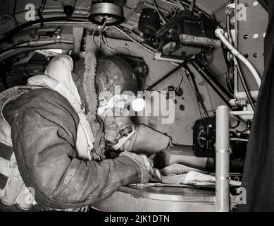 Le navigateur d'un Avro Lancaster B Mark III du RAF de l'escadron n° 619 assis à sa table dans l'avion. Les « Lancs » ont été les premiers à intervenir auprès du commandement de l'bombardier de la RAF en 1942. Alors que l'offensive stratégique de bombardement sur l'Europe a pris de l'ampleur, elle est devenue le principal avion pour les campagnes de bombardement de nuit qui ont suivi. Banque D'Images