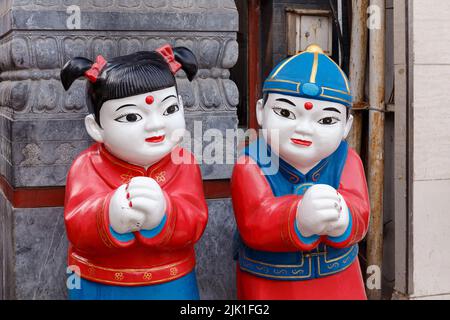 BEIJING, CHINE - 11 MARS 2018. Figurines d'une fille et d'un garçon dans une guirlande traditionnelle à un marché de rue à Pékin, Chine sur 11 mars 2018. Banque D'Images