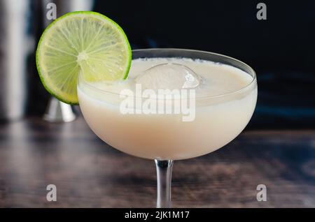 Cocktail de gin au chocolat blanc avec sphère glacée : cocktail fait de gin, de lime cordiale et de liqueur de chocolat blanc dans un verre coupé Banque D'Images