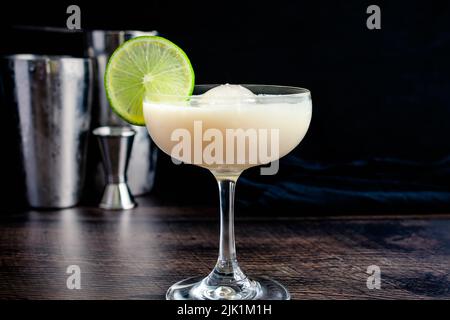 Cocktail de gin au chocolat blanc avec sphère glacée : cocktail fait de gin, de lime cordiale et de liqueur de chocolat blanc dans un verre coupé Banque D'Images