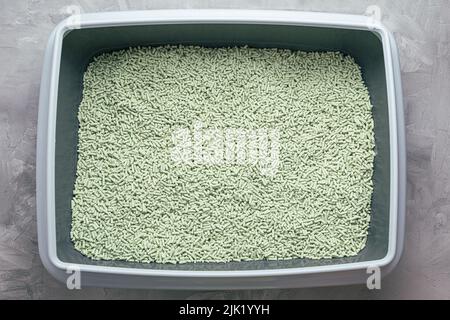 Boîte à litière pour chats avec litière en tofu biodégradable et lavable naturel et parfum de poudre de thé vert. Produit écologique pour animaux domestiques. Vue de dessus, espace de copie Banque D'Images
