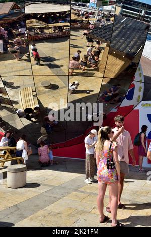 Personnes à Bristol Millennium Square avec des réflexions dans le globe miroir Banque D'Images