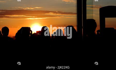 Personnes prenant des photos au coucher du soleil depuis la tour Montparnasse à Paris, France Banque D'Images