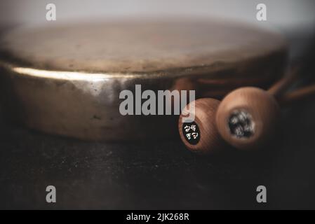 Jing Korean traditionnel Gong avec des pilons sur fond sombre moody Banque D'Images