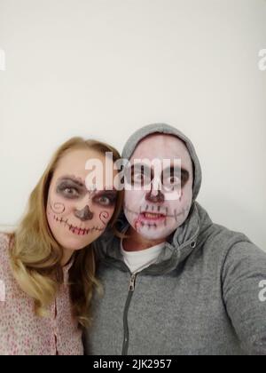 Jeunes gens avec un crâne peint sur leur visage sur un fond blanc. Célébration du jour des morts Banque D'Images
