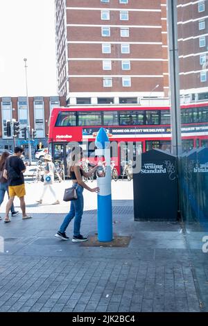 Londres, le 2022 juillet : une femme remplit une bouteille d'eau réutilisable à une fontaine de Shepherds Bush Banque D'Images