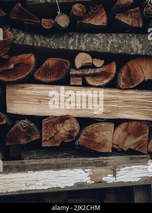 Mur de bois de chauffage sec haché de bûches empilées l'une sur l'autre dans un tas. Arrière-plan en bois texturé Banque D'Images