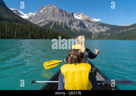 Deux femmes adultes pagayaient sur un canoë sur Emerald Lake dans le parc national Yoho en Colombie-Britannique, au Canada Banque D'Images