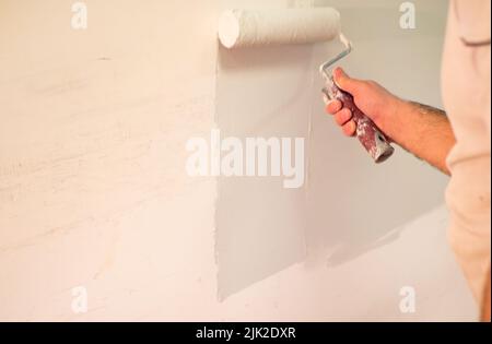 Décorateurs peinture à la main mur avec rouleau Banque D'Images