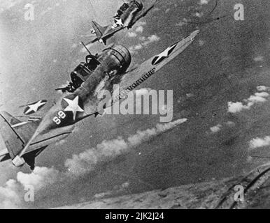 U.S. Navy Douglas SBD-3 bombardiers de plongée Dauntless de l'escadron de Scoutisme 8 (VS-8) du porte-avions USS Hornet (CV-8) approchant le croiseur lourd japonais en feu Mikuma pour faire la troisième série d'attaques contre elle, pendant la bataille de Midway, le 6 juin 1942. Banque D'Images