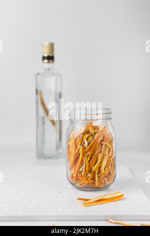 Faire de l'extrait d'orange, peler l'orange dans un bocal en verre, émincé de zeste d'orange Banque D'Images