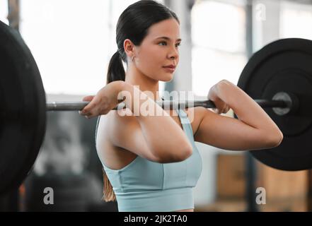 Un corps en forme, actif et musculeux musculation femmes poids de levage dans la salle de gym exercice pour améliorer la force et le conditionnement. Jeune femme entraînement d'athlète Banque D'Images