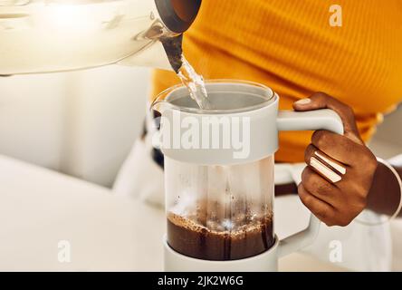 Les femmes font du café le matin à déguster avec le petit déjeuner, en versant de l'eau chaude de la bouilloire dans une cuisine. Gros plan d'une femme noire décontractée préparant ou Banque D'Images