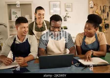 Créateurs de mode, collègues et créatifs parcourant un ordinateur portable pendant une réunion pour réfléchir à une gamme de vêtements dans un atelier. Équipe de planification de la conception de vêtements Banque D'Images