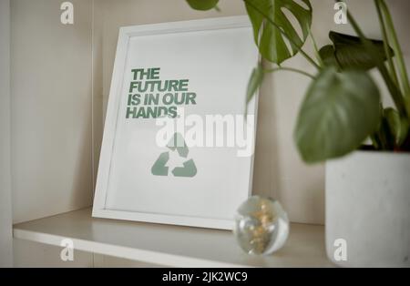 Panneau de développement durable, de développement durable et de recyclage près d'une usine de pot vert. Affichage de la réutilisation et de réduire l'image de cadre sur un placard d'une maison ou maison. Le Banque D'Images