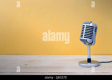 Microphone vintage isolé sur fond en bois et jaune Banque D'Images