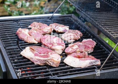 Morceaux de viande fraîche brute placés sur une grille. Banque D'Images