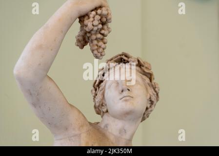 NAPLES, ITALIE - 06 MAI 2022 - Sculpture d'un jeune homme mangeant à partir d'un raisin de vin, Italie Banque D'Images