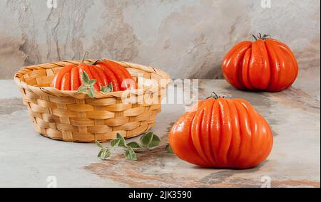 Un groupe de grosses tomates Costoluto avec origan sur fond marron, espace pour le texte Banque D'Images