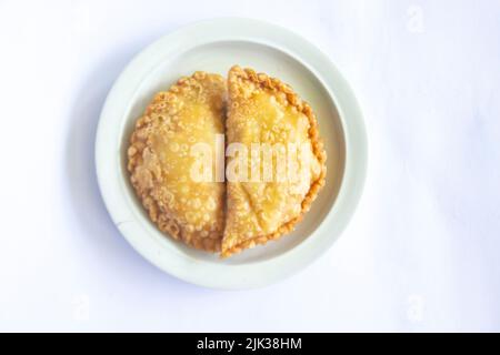 gâteau de pasties ou gâteau de pâtisserie ou kue pastel servi avec du piment vert dans une petite assiette sur fond de bois. gâteau indonésien pastel Banque D'Images