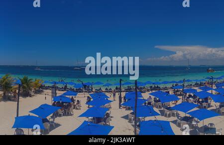 Parasols bleus sur une plage sur Isla Mujeres au Mexique Banque D'Images