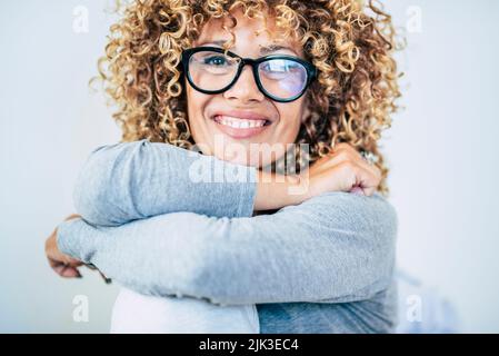 Portrait d'une jeune femme adulte souriant à l'appareil photo et portant des lunettes. Blonde couvre-cheveux longs et bouclés la femme aime la vie. Bonne et joyeuse sourire. Avant v Banque D'Images