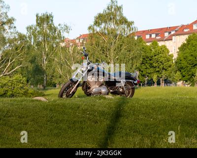 Harley-Davidson moto debout dans la nature verte. Parking de la moto sur un chemin naturel. Vue latérale du vélo noir. Style de vie américain Banque D'Images