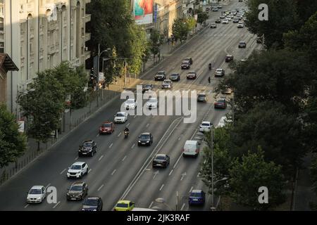 Bucarest, Roumanie - 30 juillet 2022 : voitures sur le boulevard Magheru à Bucarest au coucher du soleil. Banque D'Images