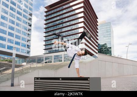 Homme d'affaires adulte heureux et séduisant portant un costume élégant faisant acrobatic trick se déplace dans la ville, concept alternatif pour la publicité d'affaires avec Banque D'Images