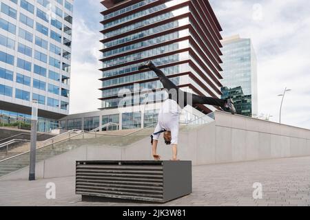 Homme d'affaires adulte heureux et séduisant portant un costume élégant faisant acrobatic trick se déplace dans la ville, concept alternatif pour la publicité d'affaires avec Banque D'Images