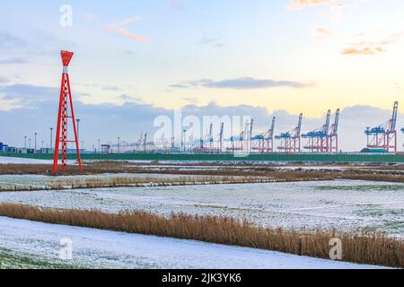 Zone industrielle grues et phare de la tour rouge avec de belles prairies et dike dike nature paysage marin panorama à Imsum Geestland Cuxhaven Bas Saxo Banque D'Images